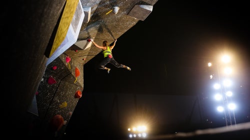 Emily Harrington dances between holds on the women's third route of the finals. Here, she swings over the wall's lip to reach the problem's top hold.
