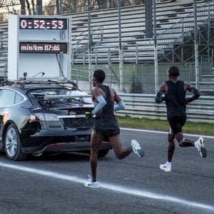 Runners behind a Tesla time car during Nike's March 7th half marathon test at the Formula One racetrack in Monza, Italy.