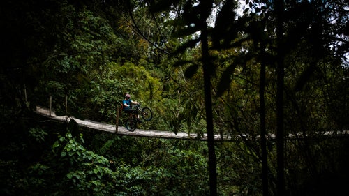 Guatemala isn鈥檛 known for its mountain biking. And that鈥檚 a good thing. This yet-to-be-overrun spot is littered with great riding on everything from mountainous Mayan footpaths to carefully placed flow trails that run through lush jungles. Last month, photographer Max Whittaker followed Diamondback rider Eric Porter and a couple of guests as they sampled the goods.
PHOTO: Eric Porter wheelies across a suspension bridge during a 12-mile flow-trail descent through dense cloud forest at the private El Zur Mountain Bike Park outside the city of Antigua. The trail took more than four years to build.