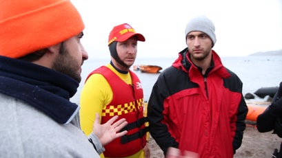 Lifeguards prepare for a large boat of refugees coming to shore.