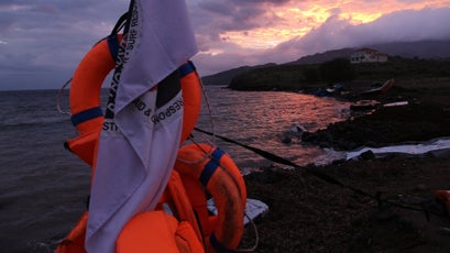 Lifejackets of refugees hang from a boat at sunset. Syrian refugees on the Turkish side will sometimes pay smugglers a large fee for a seat on a makeshift boat (often duct taped together). Many of these refugees were forced to buy fake lifejackets, often stuffed with packing material that made people sink faster.