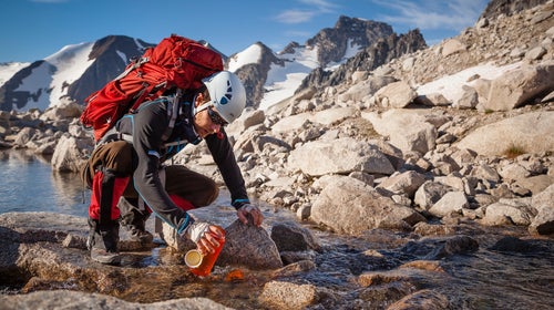Kaare Iverson fills his water bottle from a glacial stream on the way to a climbing route in Bugaboos Provincial Park, British Columbia