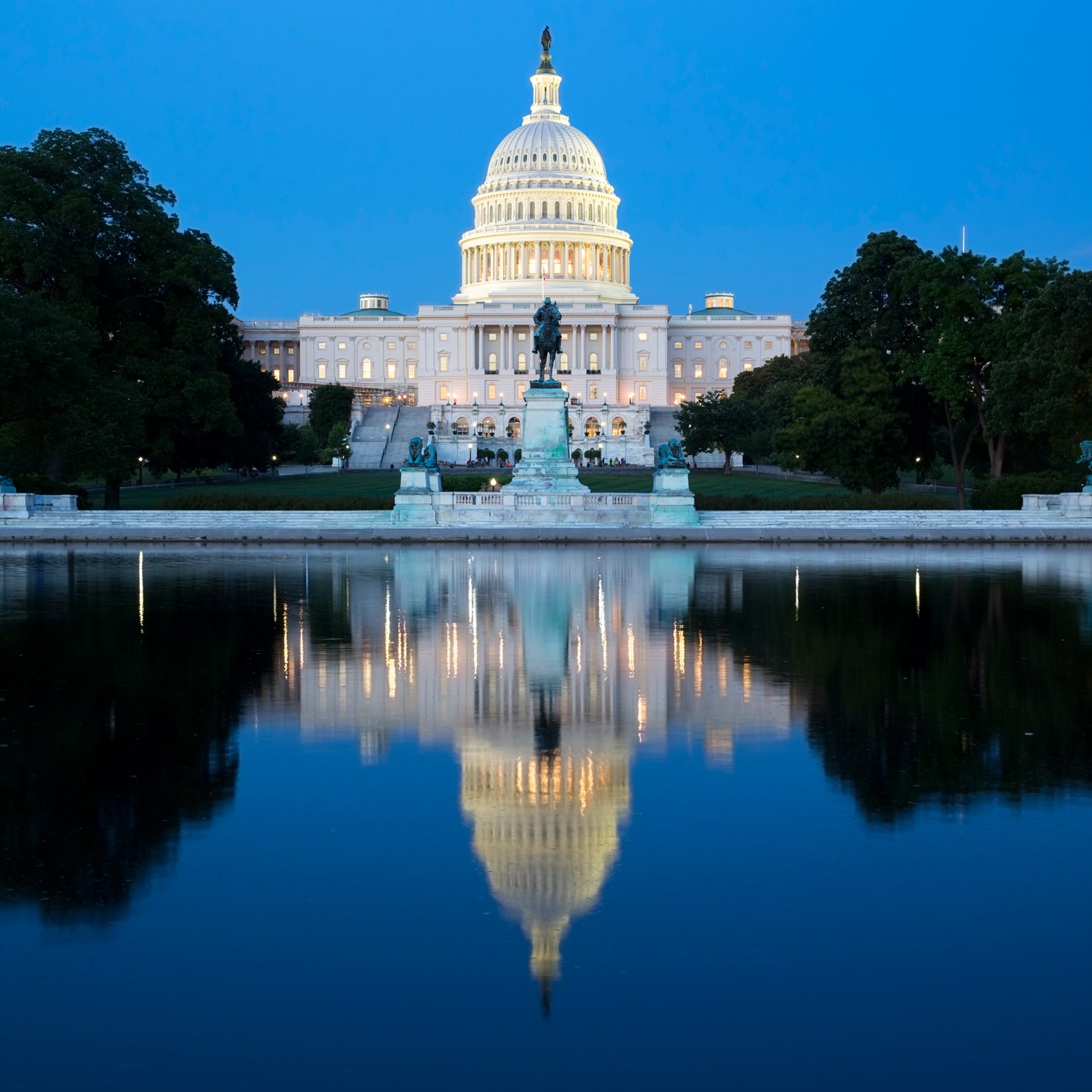 The Capitol Building and Reflecting Pool in Washington D.C. America, illuminated at night.