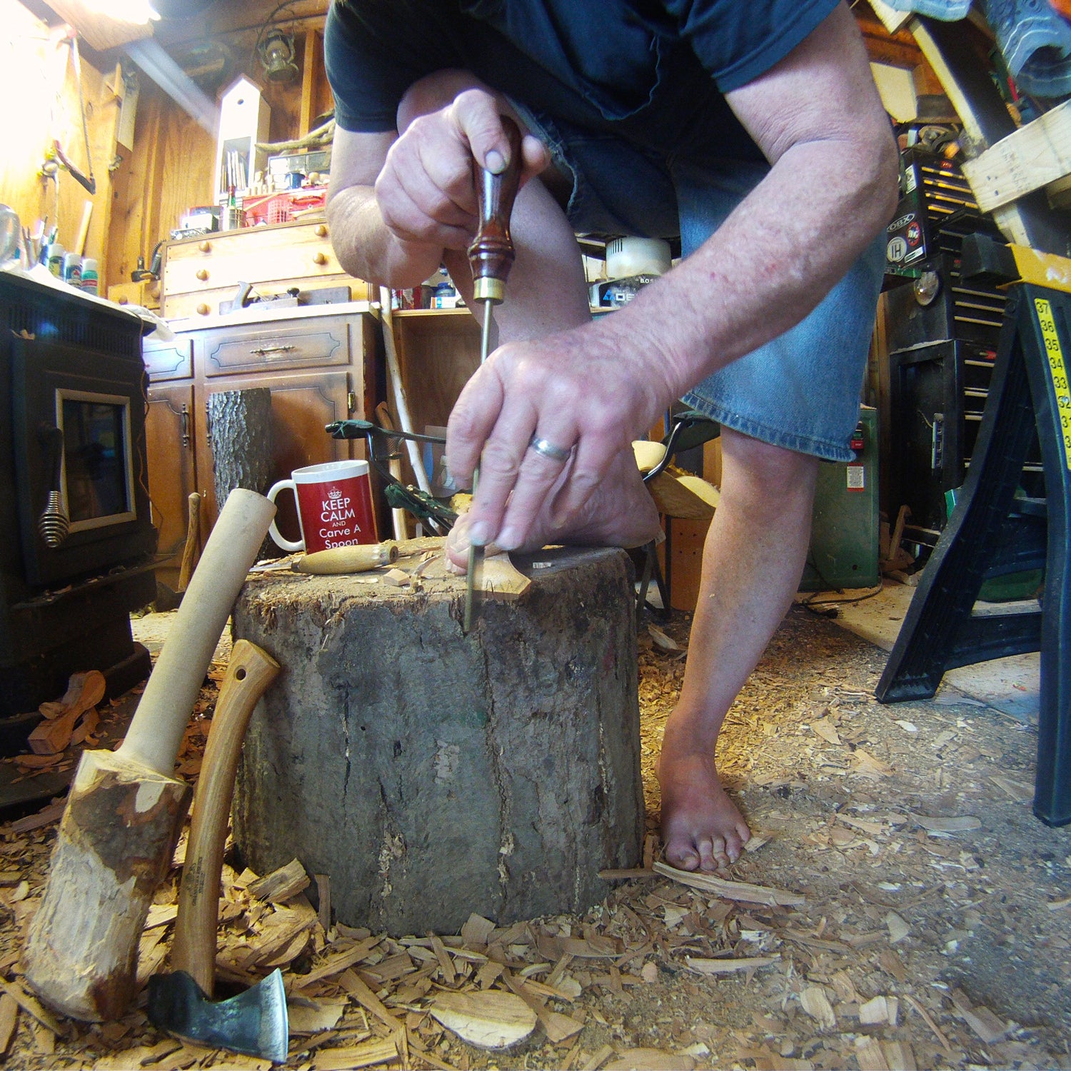 Tabor uses his feet to help him carve these wooden spoons for AT hikers.