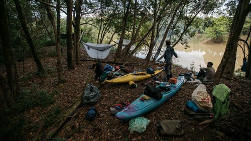 On April 11, kayaker Jules Domine stretches at the bank of the river while Aniol Serrasolses sits behind him. Also on the expedition was Chris Korbulic, a professional paddler and photographer and Stookesberry鈥檚 long-time paddling partner, and Jesse Rice, an American competitive kayaker who had recently guided in Chile.