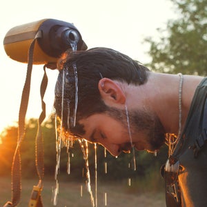 hiker Man dropping fresh water on his head
