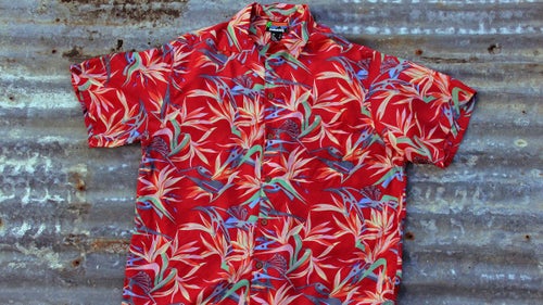 The Original Pataloha Climbing Hardware Shirt
Here’s what Jocelyn Slack remembers about this 1987 design, a confluence of sea and mountains, as visualized through the cracked windshield of a beater roadtrip mobile. (See if you can spot the pitons and ice ax heads in the artwork.)
“The inspiration for the bird of paradise pitons and the flamingos came from my experience of arriving in Southern California to work in Ventura, usually in winter, driving down from [Jackson,] Wyoming. The warm air, ocean, and all the flowers, the ‘tropicalness,’ was a heady sensation, never diminished by repeat visits. The pitons are beautiful pieces of design, each unique, like a flower. Their shape looked almost birdlike, so it was interesting to weave them in with the flowers, which also look like birds.