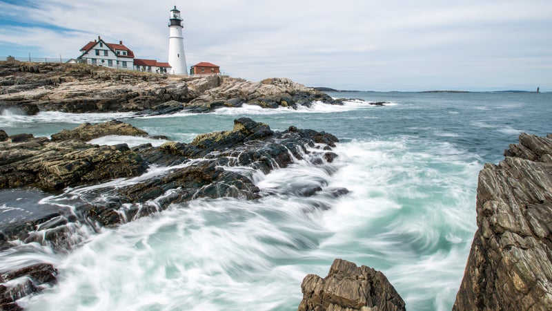 The famous lighthouse at Portland Head rests confidently above the crashing surf in Cape Elizabeth, Maine.