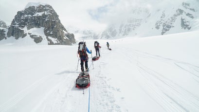 Lucy and her team walking with gear up Denali.