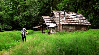 A hiker approaches the Olympus Ranger Station along the Hoh River trail.
