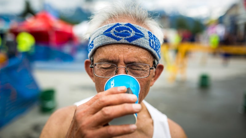 Chad Resari, this year's oldest racer at 81 years old, drinks up at the finish line.