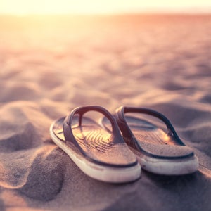 Flip flops on the beach at sunset