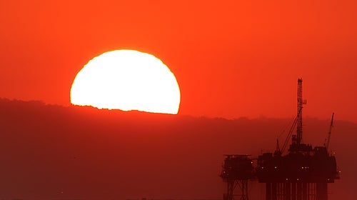 The sunset over an oil rig off the coast of Huntington Beach, CA.