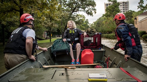 Volunteers with Team Rubicon help rescue a woman and her cat during the aftermath of Hurricane Harvey.