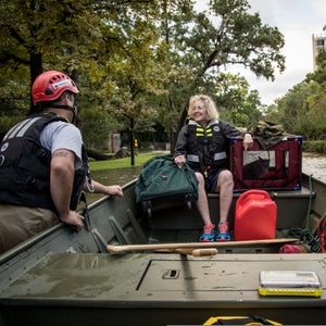 Volunteers with Team Rubicon help rescue a woman and her cat during the aftermath of Hurricane Harvey.