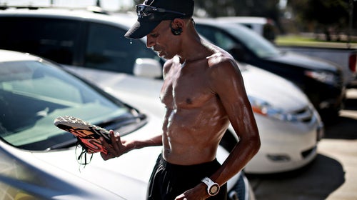 Meb Keflezighi looks over one of his shoes after a training run in San Diego, CA.