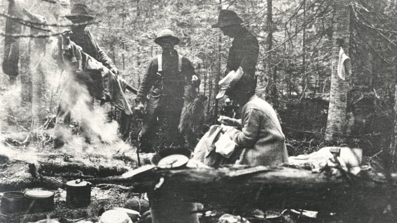 Mina Hubbard and three men around campfire, 1905.