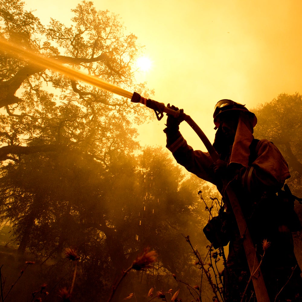 Napa County firefighter Jason Sheumann sprays water on a home as he battles flames from a wildfire Monday, Oct. 9, 2017, in Napa, Calif. Wildfires whipped by powerful winds swept through Northern California sending residents on a headlong flight to safety through smoke and flames as homes burned. (AP Photo/Rich Pedroncelli)