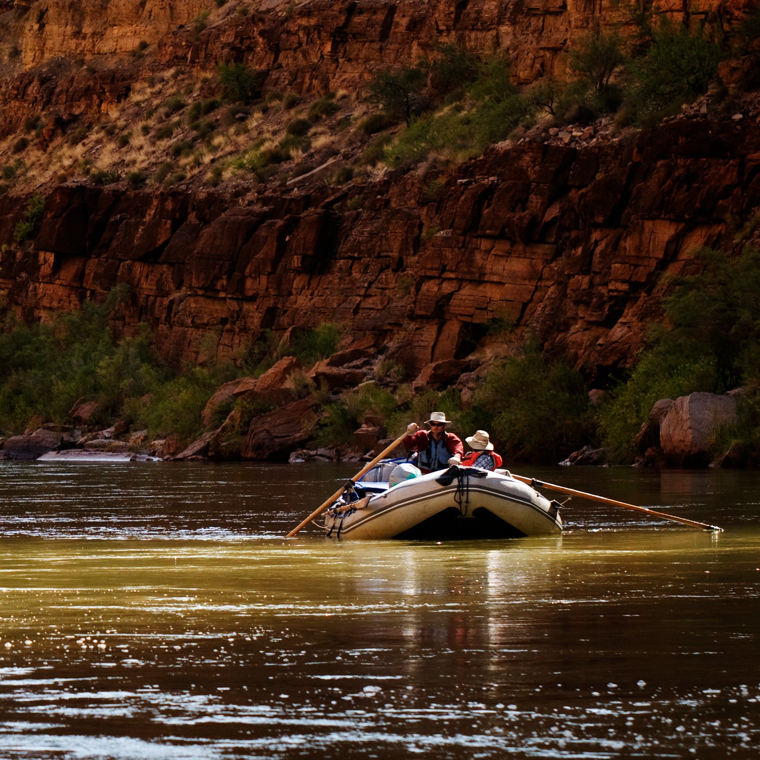 A raft floats downstream during a whitewater rafting trip on the Colorado River through Grand Canyon National Park, AZ