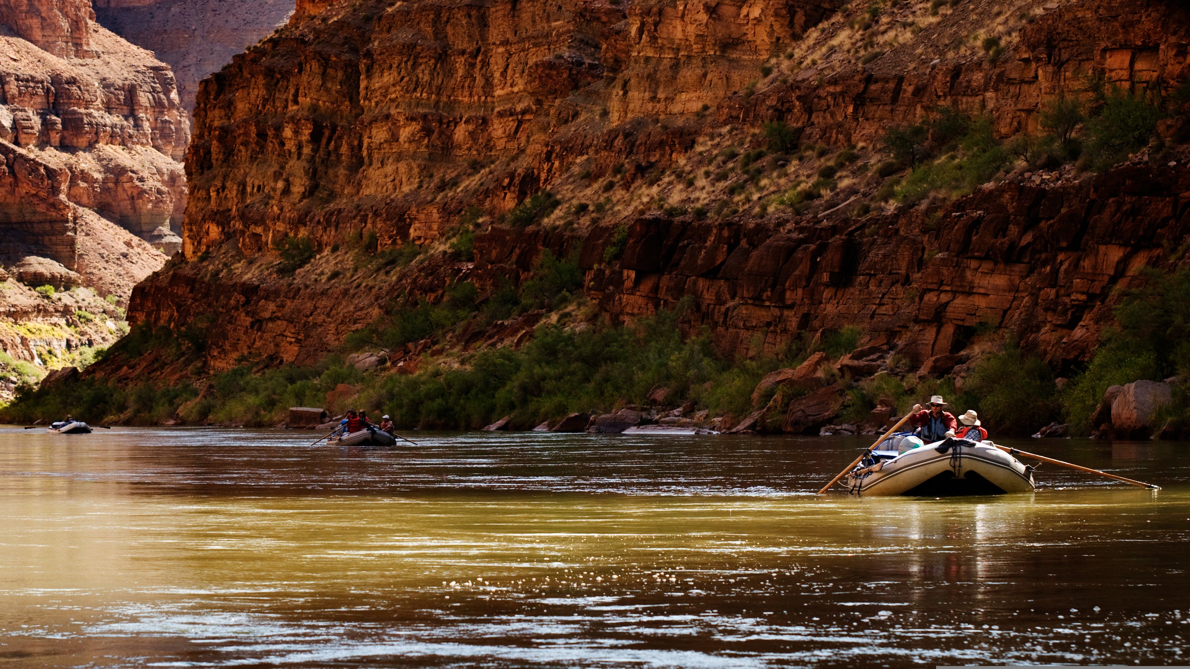 A raft floats downstream during a whitewater rafting trip on the Colorado River through Grand Canyon National Park, AZ