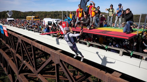 Spectators line up along West Virginia's New River Gorge Bridge to watch BASE jumpers leap off the railing toward the river 876 feet below.
