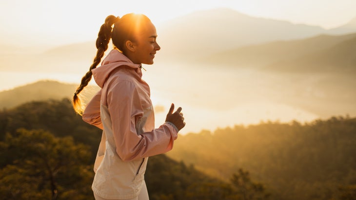 runner smiling on early morning jog in mountains