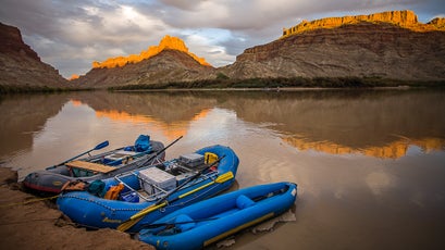 Rafts sit anchored to the shore of the Colorado river at Spanish Bottom as the sun sets on the peaks behind, Canyonlands National Park, Utah. Photo taken during a raft trip down the Colorado river from Moab to Lake Powell through Canyonlands National Park and Cataract canyon, Utah.