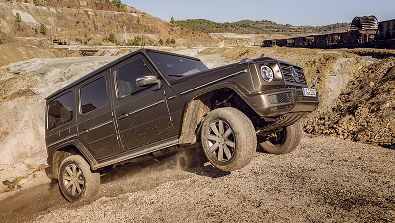 Contrast this photo with the video above. Anytime you see an SUV with a wheel off the ground, it's actually a sign of how limited that vehicle's articulation is. The previous, solid-axle G-Wagen would have been able to keep that front right wheel on the ground through this obstacle, and the body would have remained closer to level. More wheels on the ground equals more traction, equals a better potential for forward progress. A more level body equals less chance of rollover.