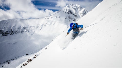 Steve Lowry skiing above the Pinnacles with Lone Peak in the distance. Big Sky Resort, Montana