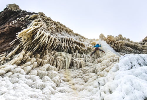 Lake Superior creates extremely unique ice formations. The combination of the wind and the spray from waves slamming into the cliffs below covers vegetation around the top of the cliff line. Climbing these formation is a formidable challenge for the Midwest adventure seekers. Here Joseph Thill climbs Bridal Veil Falls rated WI 4 in Munising, Michigan.