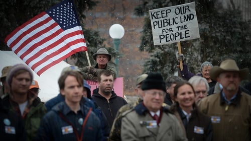 File Image: Outdoor enthusiasts Chris Madson (holding American flag) and Nancy Nixon (holding sign) show their support during a rally at the Denver, Colorado Capitol February 25, 2015 against the transfer and sale of public lands.