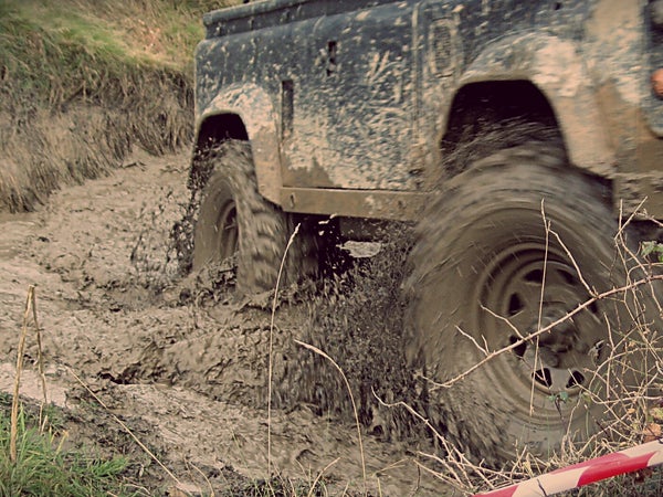 A Land Rover plugs some mud in four-wheel drive