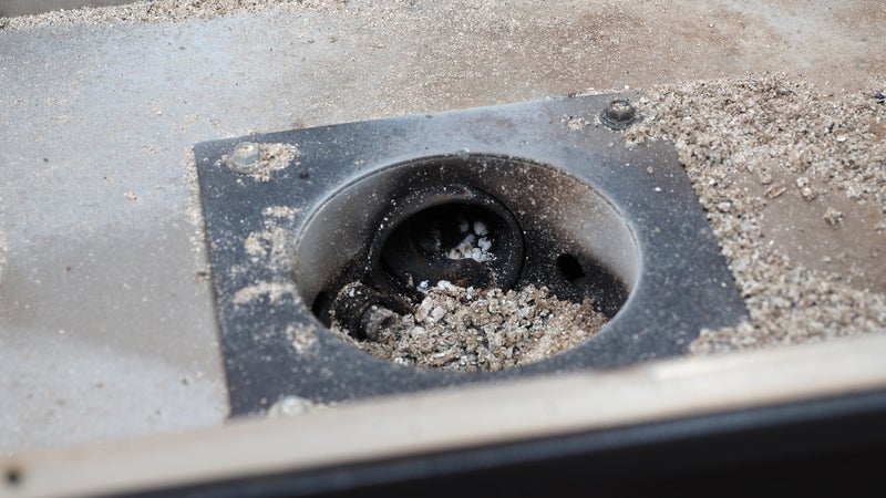 The auger draws pellets from the hopper into the fire pit.