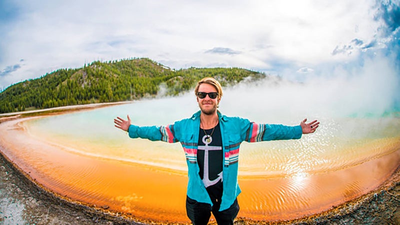 One group member standing on the edge of Grand Prismatic Hot Spring, damaging its fragile and unique bacterial ecosystem, and risking his life in an apparent attempt to inspire other to do the same. Areas like this in Yellowstone are clearly signposted and fenced, and ample educational material on the sensitive and dangerous nature of these thermal features exists throughout the park.