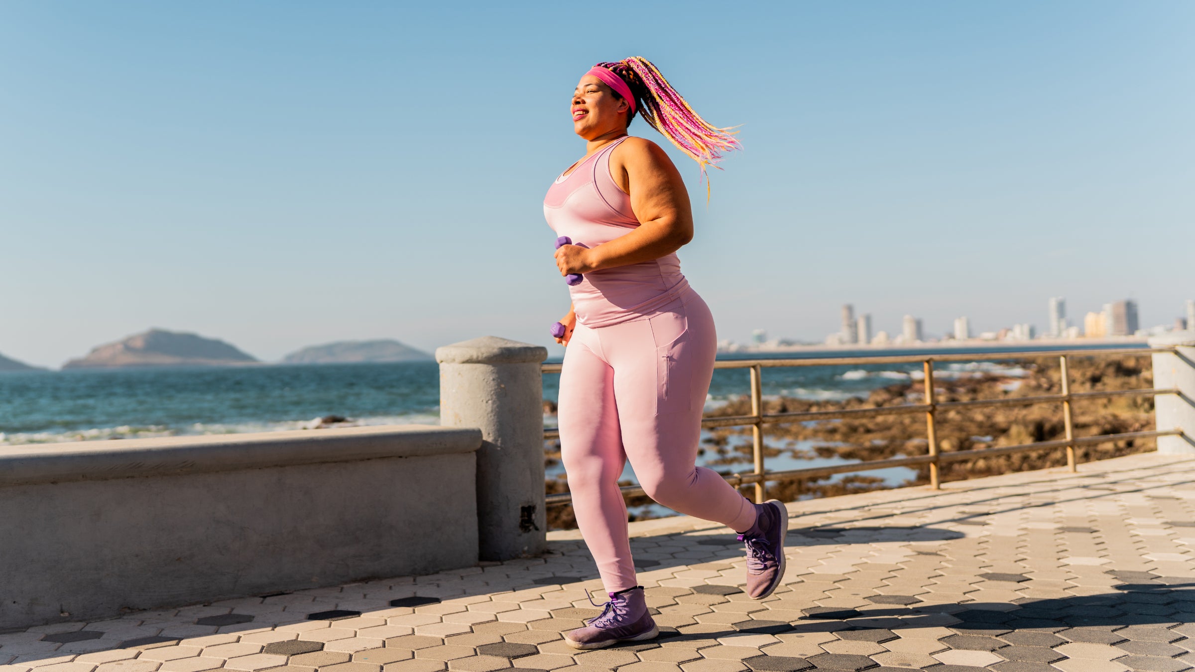 woman running in pink matching set with colorful braids