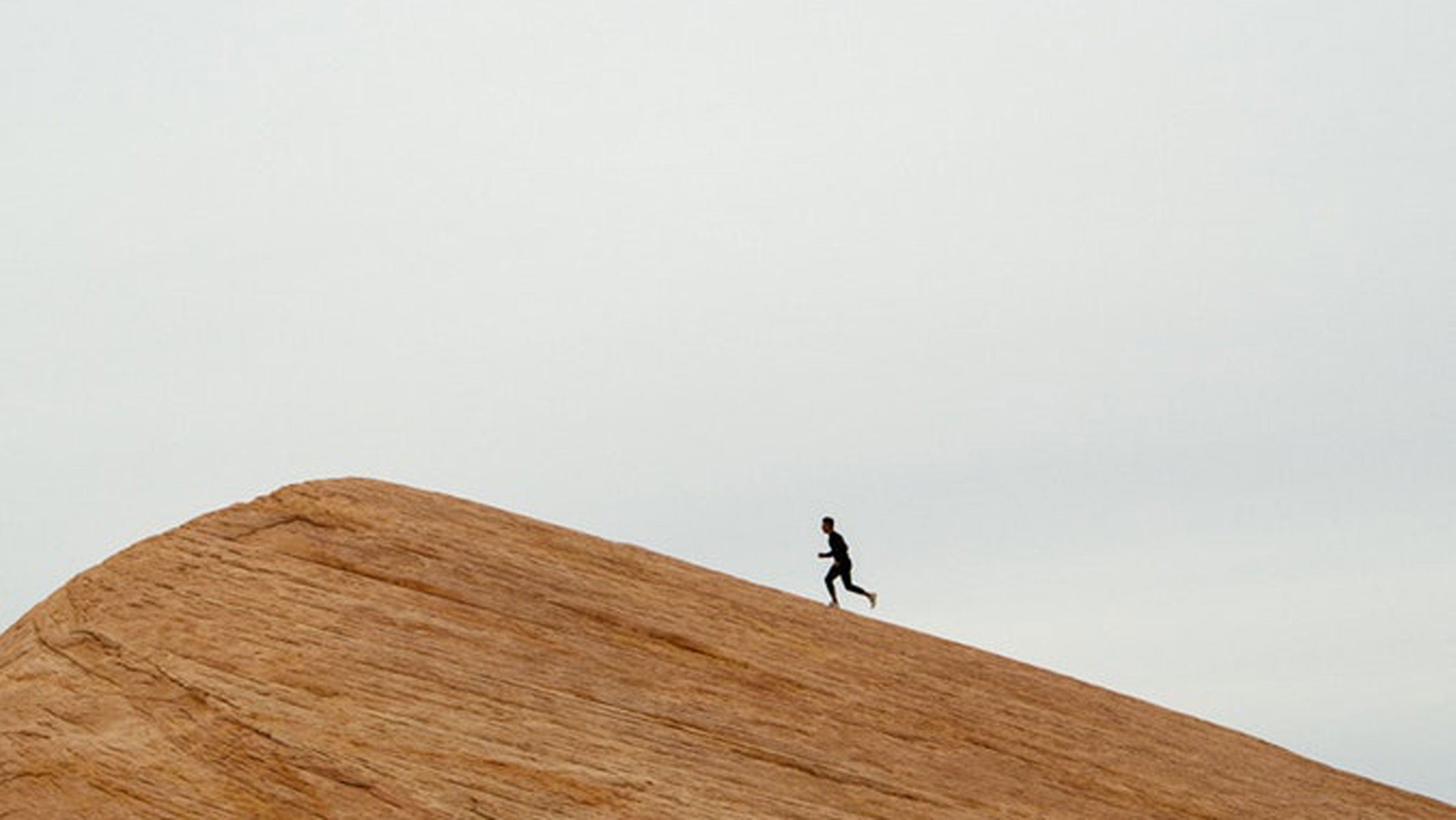 Man running up sandstone rock