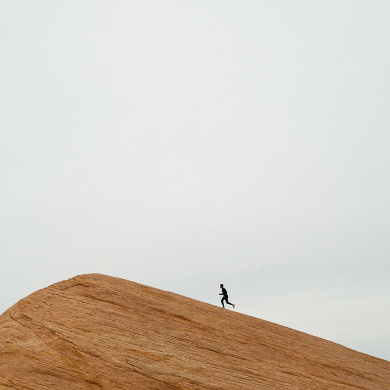 Man running up sandstone rock