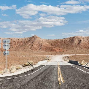 Road in red desert with blue sky