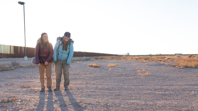 Claire Wernstedt-Lynch and Tenny Ostrem share a light moment near the border wall in Columbus, New Mexico, in January.