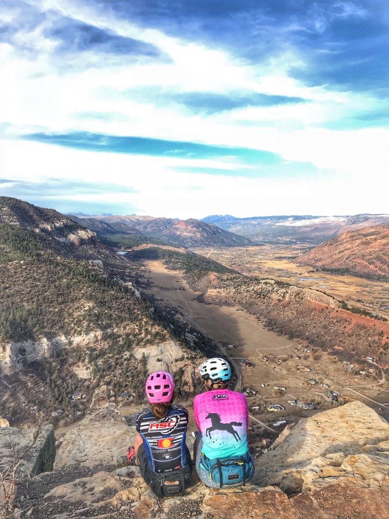 Aleah Austin (left) and Tina Ooley sitting near the shrine they built for Tricia Shadell outside Durango, Colorado.