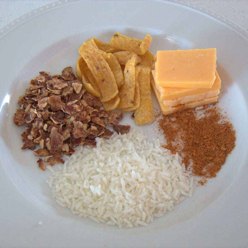 Clockwise from cheese in upper right: Cheese, taco seasoning, rice, refried beans, and Fritos