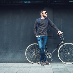 guy wearing a school backpack near a bike
