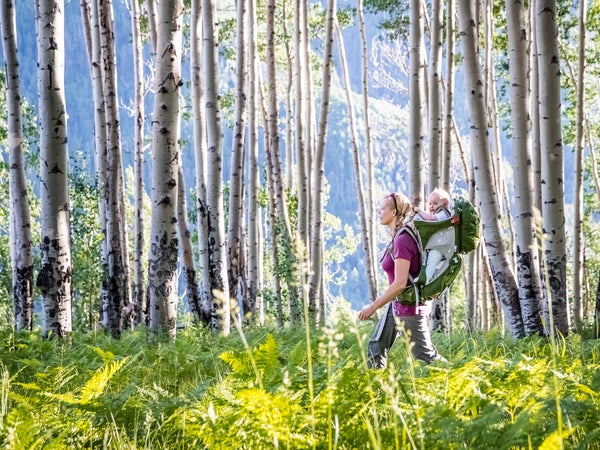 woman walking in the woods with the best baby carriers for hiking