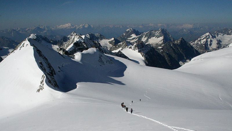Hikers headed towards Pigne d'Arolla during their traverse of the Haute Route.