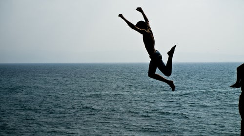 A man jumps off a cliff.