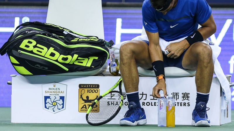 Tennis player Rafael Nadal meticulously arranges his bottles during a match.