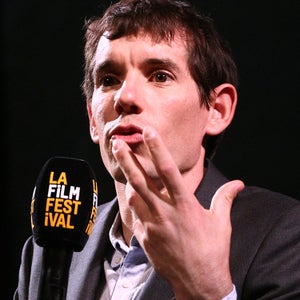 Sanni McCandless watches Alex Honnold, or perhaps his hands, as they speak onstage at a 
