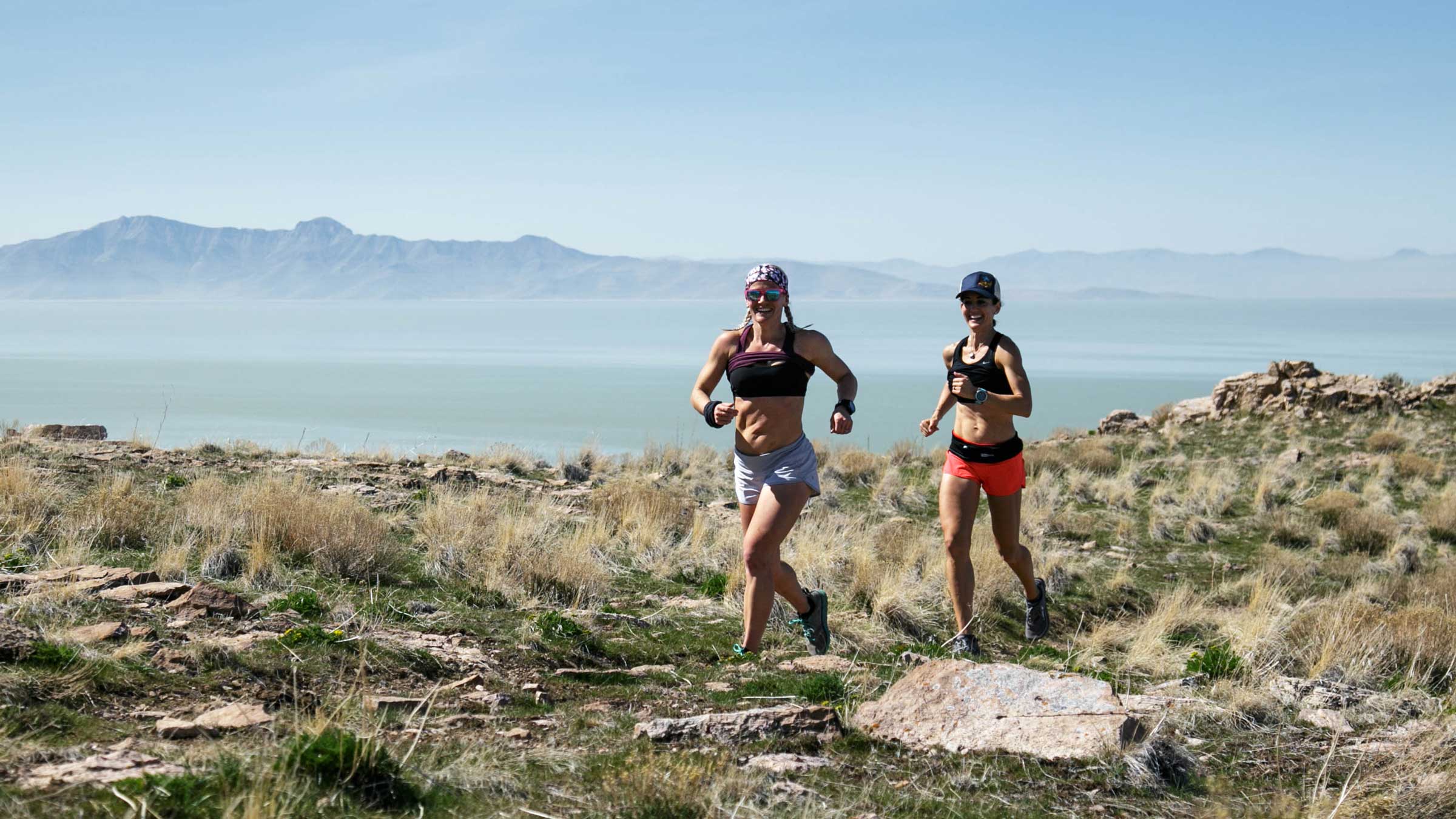 Two runners cresting a hill in Antelope Island State Park.