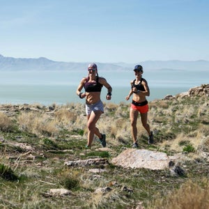 Two runners cresting a hill in Antelope Island State Park.