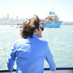 Boyan Slat watches as System 001 is towed out of the San Francisco Bay in September.